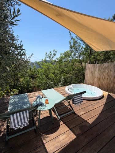 a wooden deck with a table and chairs on it at Stecadó Glamping in Dolceacqua