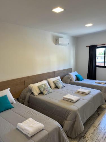 a room with two beds with towels on them at Hotel Storge in Villa Carlos Paz