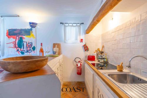 a kitchen with a sink and a wooden bowl on the counter at San Pantaleo Charme in San Pantaleo