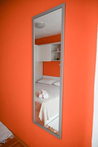 a mirror on a wall with a bed in a room at Apartmani Filip i Jakov in Senj