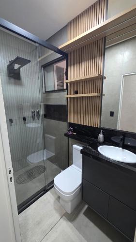 a bathroom with a toilet and a sink and a shower at Casa Completa e Confortável para sua Estadia in Ribeirão Preto