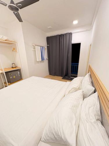 a bedroom with a large white bed with white pillows at Island Hospitality in Himandhoo 