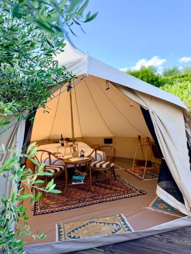 a tent with a table and chairs in it at Stecadó Glamping in Dolceacqua