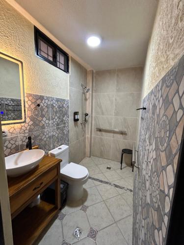 a bathroom with a toilet and a sink and a shower at Hotel La Casona Del Valle in Valledupar