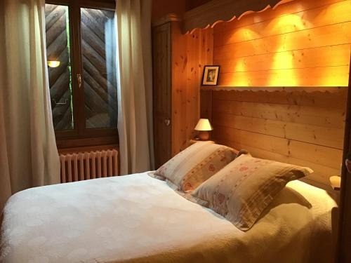 a bedroom with a white bed with a window at Au Refuge de Blanche in Verchères
