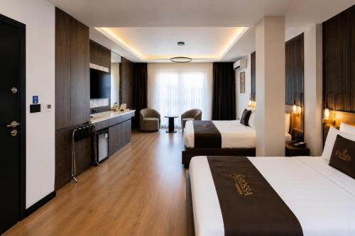a hotel room with two beds and a television at Rossa Marin Hotel in Darıca