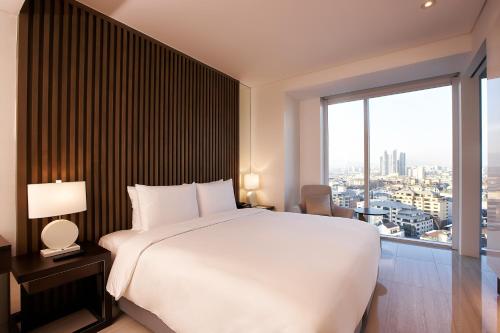 a bedroom with a large white bed and a large window at Hotel Entra Gangnam in Seoul