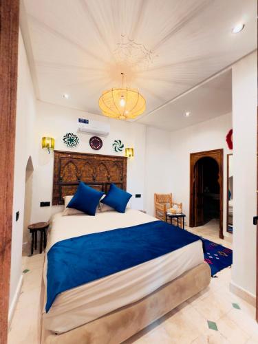 a bedroom with a large bed with blue pillows at Riad Kimee in Marrakesh