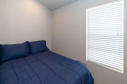a bedroom with a blue bed and a window at Sun Outdoors Ocean City in Ocean City