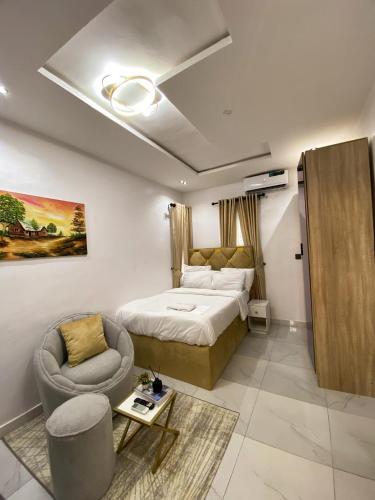 a hotel room with a bed and a chair at Declevor Homes in Lekki
