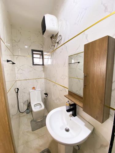 a white bathroom with a sink and a toilet at Declevor Homes in Lekki