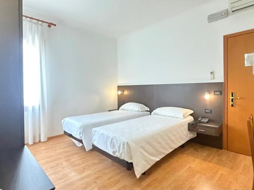 ein Hotelzimmer mit zwei Betten und einem Fenster in der Unterkunft Hotel Gran Casa in Oderzo