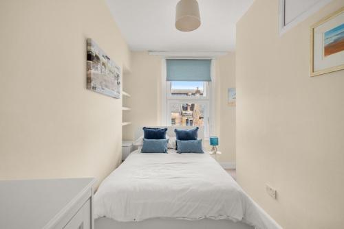 a bedroom with a bed with two blue pillows at 114 North Street in St. Andrews