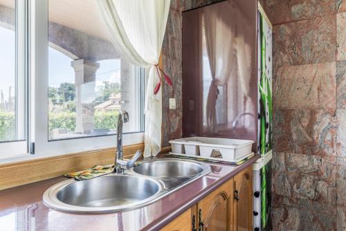 a kitchen with a sink and a window at Os Cabaleiros in Mos