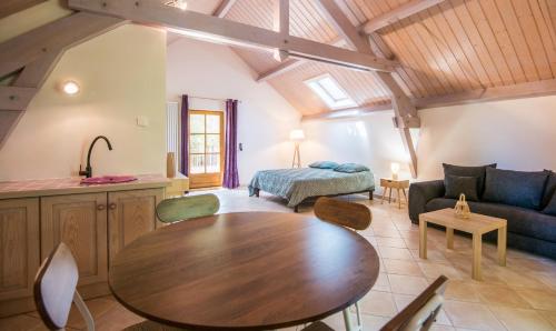 a living room with a table and a couch at L'Oustal del Sully - Villa d'exception avec piscine, proche lac de Pareloup in Prades-Salars