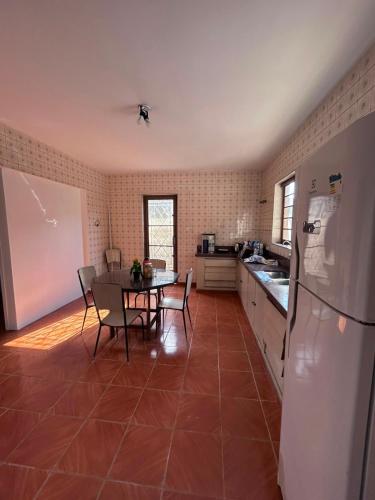 a kitchen with a table and a white refrigerator at Hospedagem da Renata in Salto