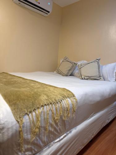 a bedroom with a large white bed with a tv on the wall at Bahay El Nido in El Nido