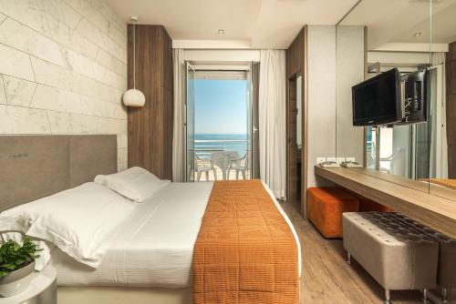 a bedroom with a bed and a view of the ocean at AmbientHotels Panoramic in Rimini