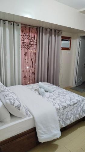a bedroom with two beds with white sheets at RPCB Condo Rental in Cagayan de Oro