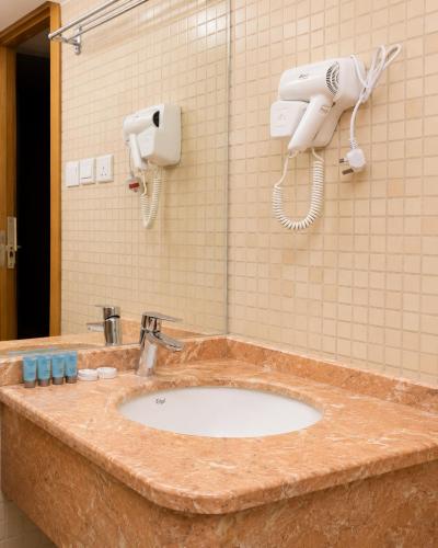 a bathroom sink with a hair dryer and a phone at فندق إتقان المشاعر in Mecca