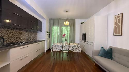 a kitchen with white cabinets and a table and a couch at Crystal House in Montesilvano
