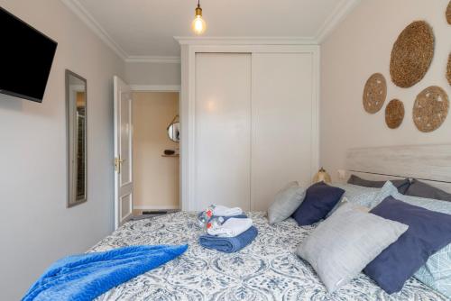 ein Schlafzimmer mit einem Bett mit blauen Kissen in der Unterkunft Apartamento Morriña in Brion
