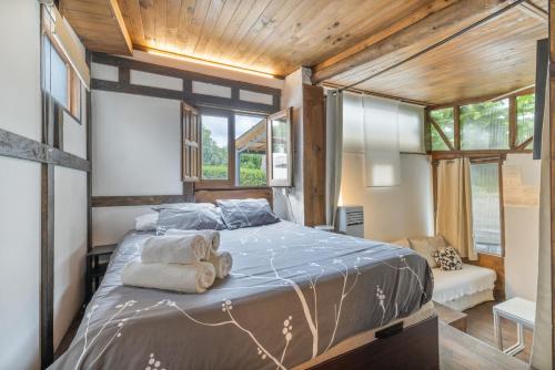 a bedroom with a large bed with towels on it at Cabañita rústica con piscinas in Cambre