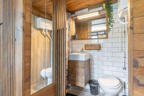 a bathroom with a toilet and a sink at Cabañita rústica con piscinas in Cambre