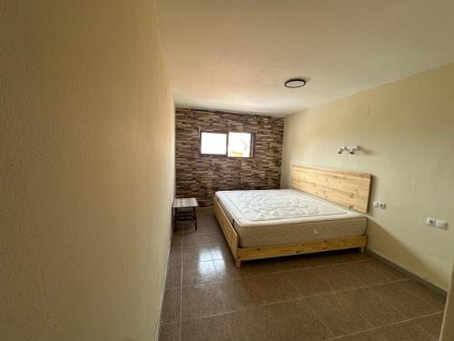 a bedroom with a bed and a brick wall at Isla de los Pensamientos in Cullera