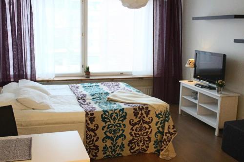 a small bedroom with a bed and a television at Jaakonkatu City Apartment in Rovaniemi