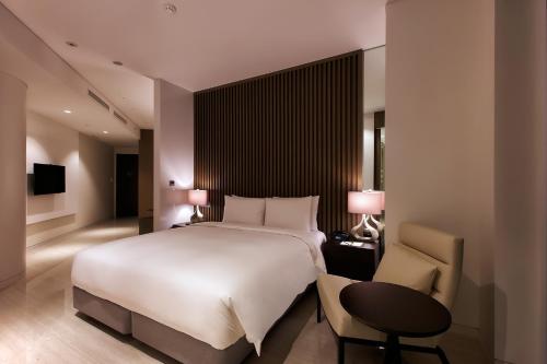 a bedroom with a large bed and a table and a chair at Hotel Entra Gangnam in Seoul