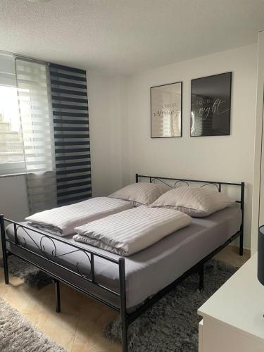 a bed with white sheets and pillows in a bedroom at Mng home in Kippenheim