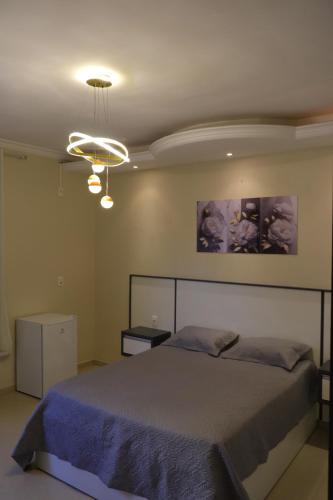 a bedroom with a large bed and a chandelier at Suíte Excellence - 01 in Pirenópolis