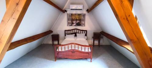 a attic room with a bed and two stairs at Gîte d'Alithe in Montamel