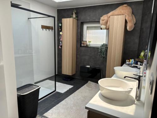 a bathroom with two sinks and a toilet and a shower at Rhythm & Rest in Boom