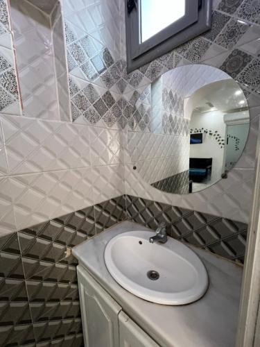 a bathroom with a sink and a mirror at Djerba Appartement in Houmt Souk