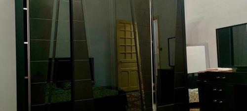 a bathroom with a glass door and a mirror at Layna in El Mouradia