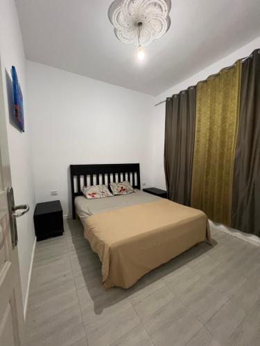 a bedroom with a bed and a chandelier at Djerba Appartement in Houmt Souk