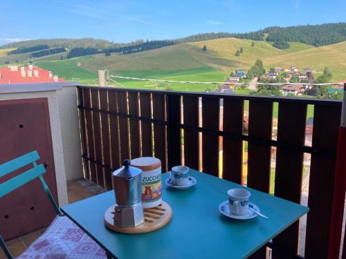 a blue table with two cups of coffee on a balcony at Chalet Iris in Bertigo