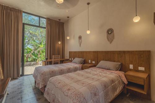 ein Hotelzimmer mit zwei Betten und einem Fenster in der Unterkunft Villas Marlé in Mococha