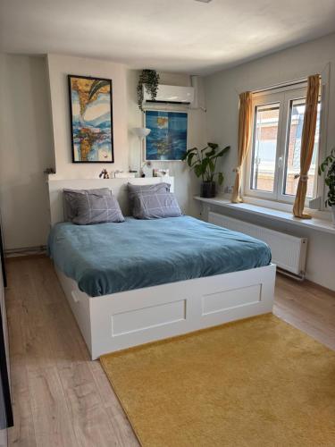 a bedroom with a large bed with a blue blanket at Rhythm & Rest in Boom