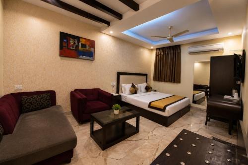 a hotel room with a bed and a couch at Hotel Kingston Park near Ganga Ram Hospital in New Delhi