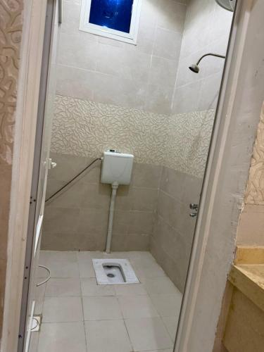 a bathroom with a toilet in the floor and a window at شقه ارضيه in Hail