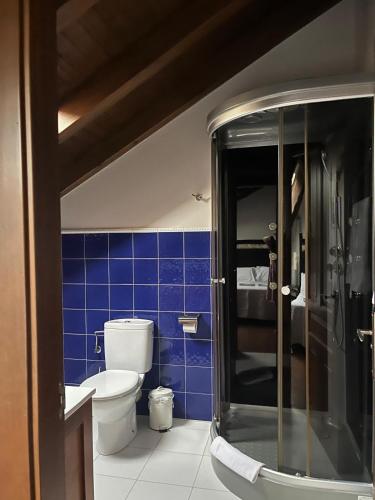 a blue tiled bathroom with a toilet and a shower at Apartamentos La Senda in San Juan de Parres