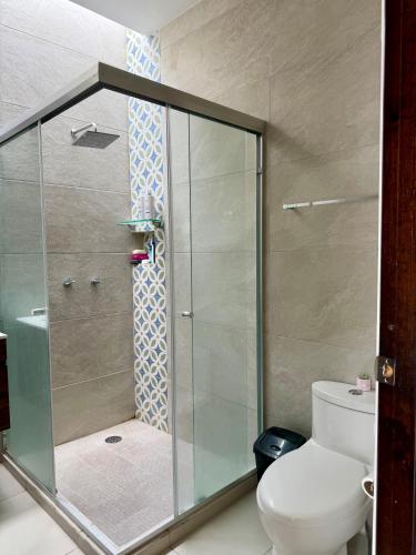 a bathroom with a glass shower with a toilet at Manzanillo Homestay Room in Manzanillo