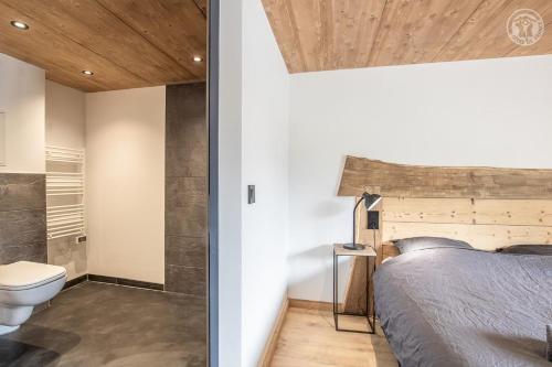 a bedroom with a bed and a toilet at Chalet de l'epigny in Bellecombe