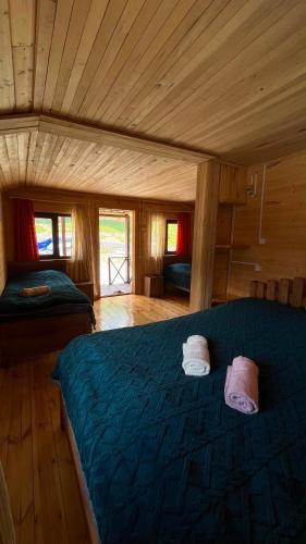 a bedroom with a blue bed in a cabin at LEMI Mountain Cottages - Ushguli in Ushguli