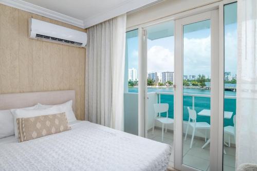 a bedroom with a bed and a balcony with a view at Premier Ocean Lagoon Studio · Condado with Pool in San Juan