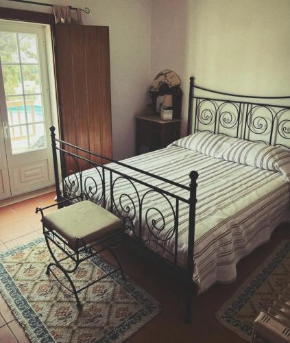 a bedroom with a bed with a chair and a window at Casa da Lua in Erra