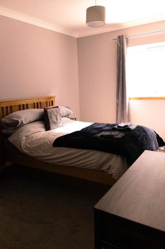 a bedroom with two beds and a window at Ardbrae Cottage in Daviot